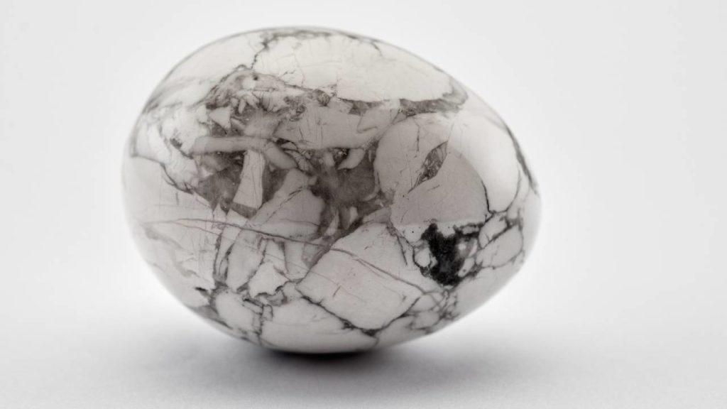 Polished howlite crystal egg on white background