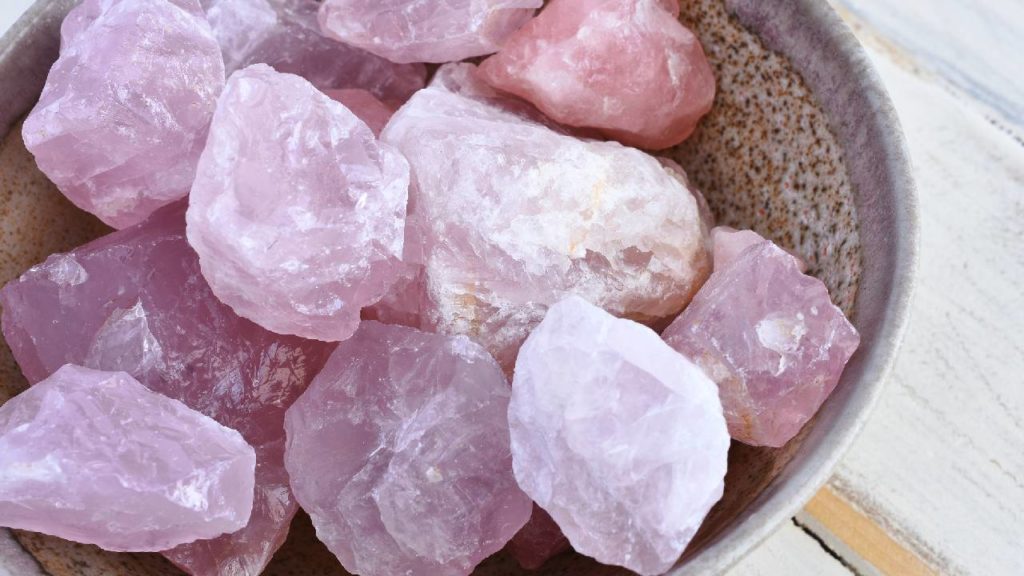Rough rose quartz stones in a bowl