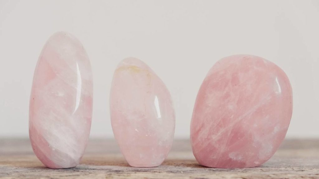 Three polished rose quartz stones