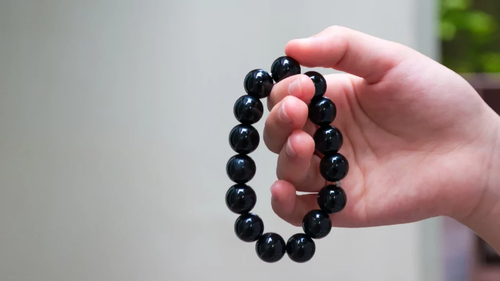 Hand holding an obsidian bracelet