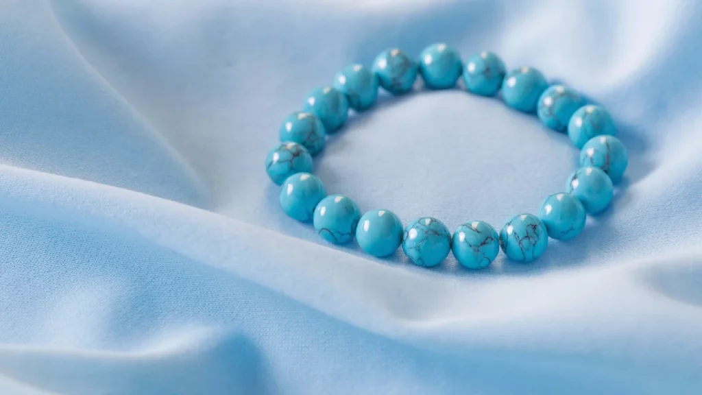 Bracelet made of turquoise stones on blue silk background