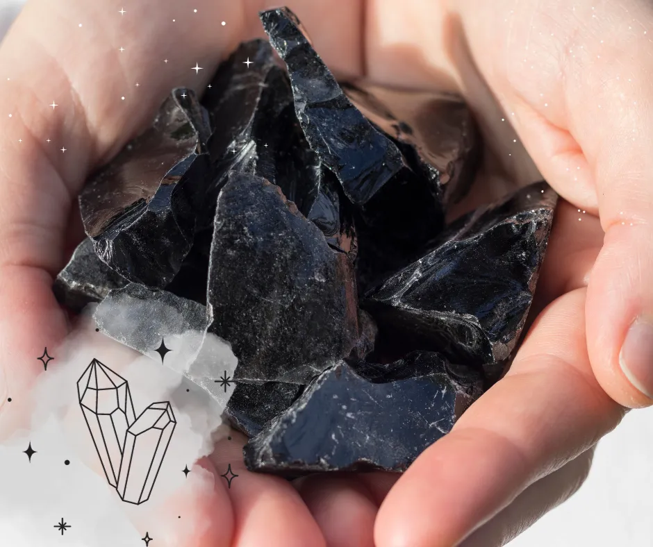 Hand holding black obsidian stones
